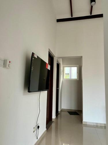 a room with a flat screen tv on a wall at Kahathuduwa Golf Residence Luxury Family Home in Kahatuduwa
