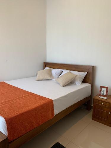 a bedroom with a bed and a night stand at Kahathuduwa Golf Residence Luxury Family Home in Kahatuduwa