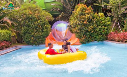 a man and woman riding on a yellow raft in a pool at Ebisu Onsen Resort in Ba Na