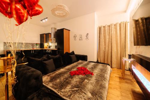 a living room with a black couch with red roses on it at Casa Amor - Adult Only Jacuzzi Suite in Southampton