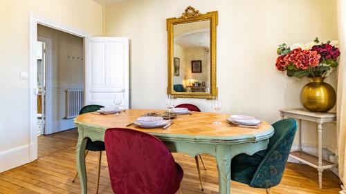 - une salle à manger avec une table, des chaises et un miroir dans l'établissement Rameau - Authentique et confort, à Dijon