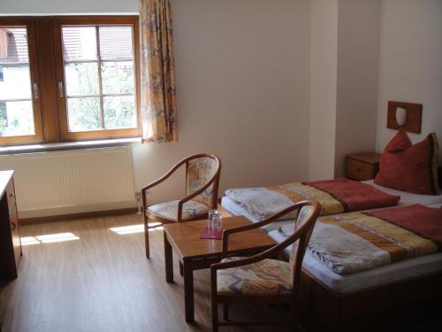 a room with two beds and a table and chairs at An der Linde in Eisenach