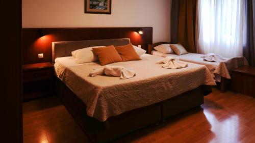 a bedroom with two beds with towels on them at Visovac Rooms in Skradin