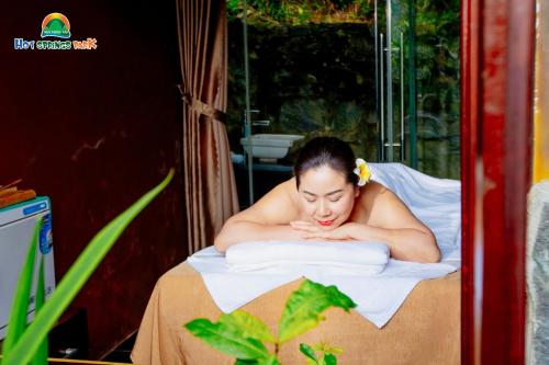 a woman laying on a bed with a towel at Ebisu Onsen Resort in Ba Na