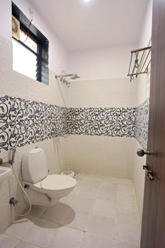 a bathroom with a toilet and black and white wallpaper at Meera Valley Resort By Nexottel in Udaipur