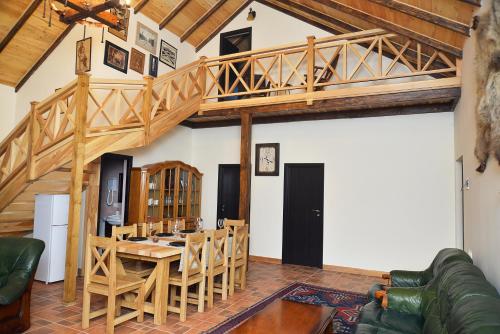 een woonkamer met een houten trap en een tafel bij Villa Jrhogher Dilijan in Dilidzjan