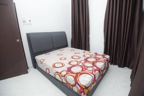 a bedroom with a bed with a colorful blanket on it at Teratak Bonda Zariah Homestay in Kota Bharu