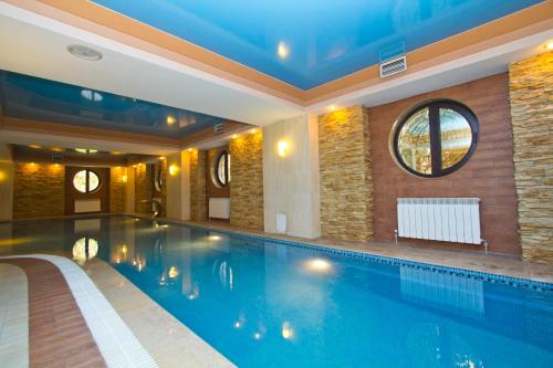 a large swimming pool in a building with a swimming pool at Hotel Kazzhol Almaty in Almaty