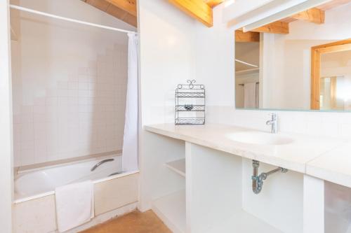 a bathroom with a sink and a tub and a mirror at Pedra Viva -Cala Bona- in Cala Bona