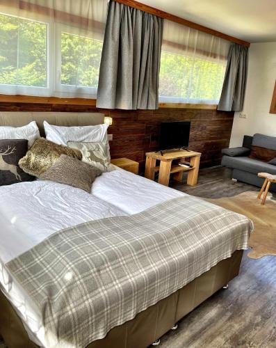a bedroom with a large bed and a living room at Chalet Maya in Schladming