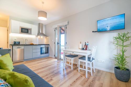 a kitchen and living room with a table and chairs at Casas das Hortas, Apartamento Vista Serra e Mar in Seixal