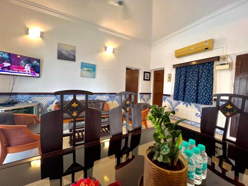 a room with a table and chairs and a tv at Nestwood - By The Beach Goa in Benaulim