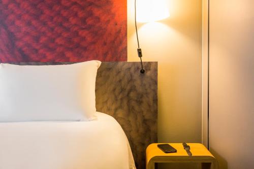 a bedroom with a bed and a table with a lamp at ibis Bordeaux Centre - Gare Saint-Jean in Bordeaux