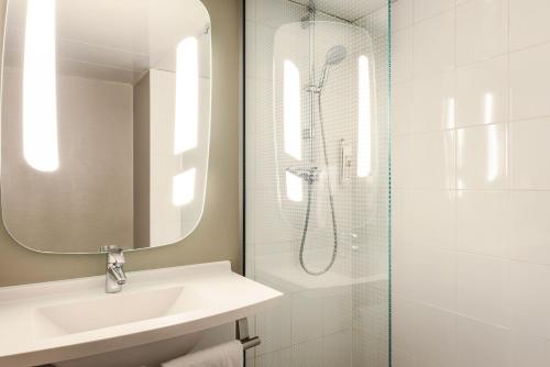 a bathroom with a shower and a sink and a mirror at ibis Bordeaux Centre - Gare Saint-Jean in Bordeaux