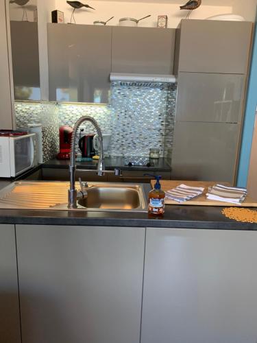 une cuisine avec un évier et un plan de travail dans l'établissement Arcachon bord de plage, à Arcachon