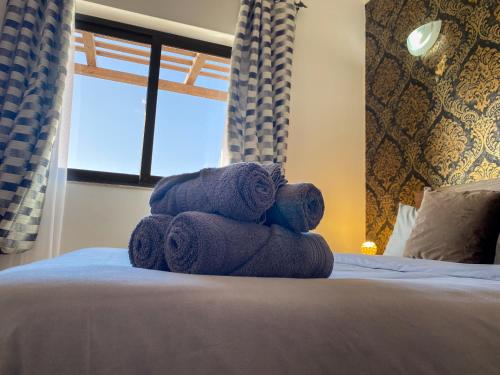a pile of towels stacked on top of a bed at KIMRAY Boutique Apartment - Indulge in Comfort, Embrace Tranquility in Marsaskala