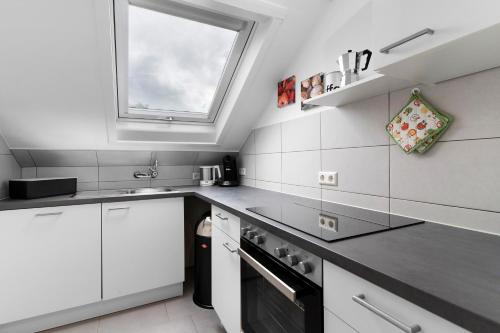 a kitchen with white cabinets and a window at Zur Stadtmama in Endingen