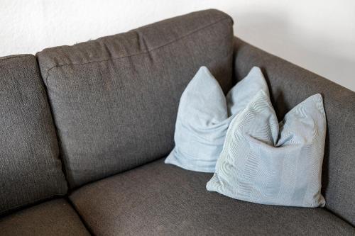 a brown couch with two pillows on it at Zur Stadtmama in Endingen