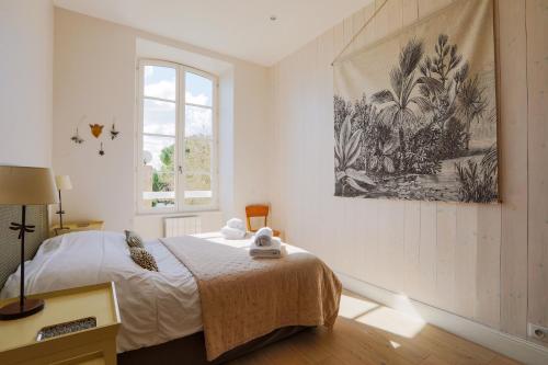 ein Schlafzimmer mit einem Bett und einem Bild an der Wand in der Unterkunft Duplex joliment décoré et sa cour ensoleillée in Saint-Martin-de-Ré