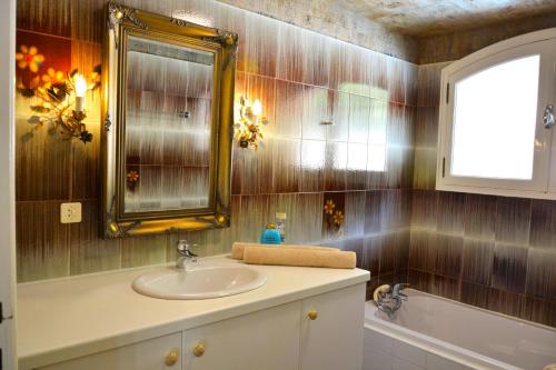 une salle de bain avec un lavabo, un miroir et une baignoire dans l'établissement Provenzalisches Haus La Grenouille - Terrasse mit Meerblick und privatem Pool by Riviera HomeLife, aux Issambres