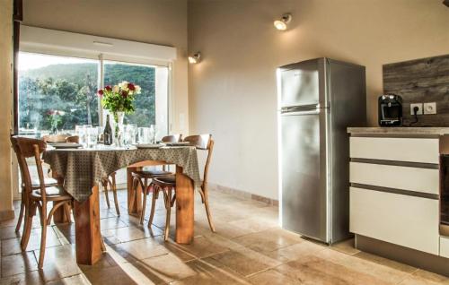 une cuisine avec une table et un réfrigérateur dans l'établissement 2 Bedroom Nice Home In Cabrerolles, à Cabrerolles