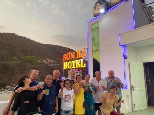 Un grupo de personas de pie frente a un hotel. en Son Ha Hotel, en Vung Tau