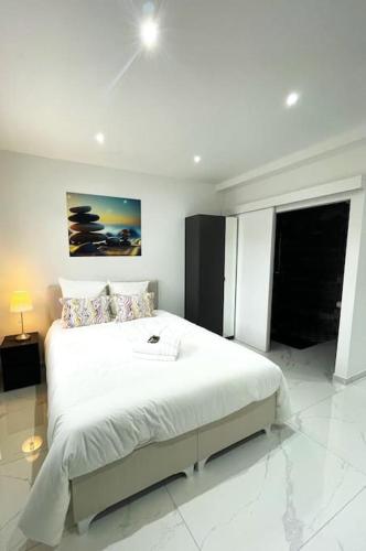 - une chambre blanche avec un grand lit blanc dans l'établissement Moderne Studio proche ORLY- Paris, à Paray-Vieille-Poste