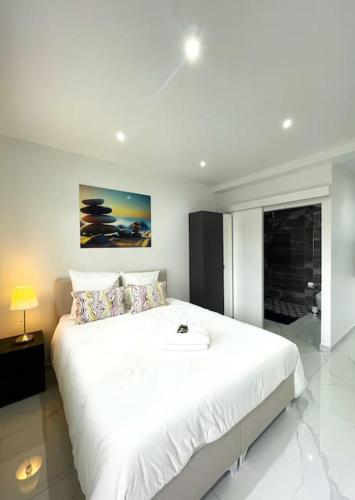 - une chambre blanche avec un grand lit blanc dans l'établissement Moderne Studio proche ORLY- Paris, à Paray-Vieille-Poste