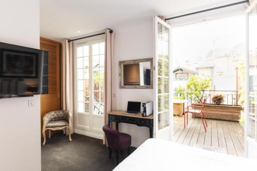 a room with a bed and a desk and a window at Boutique H&ocirc;tel Txoko in Saint-Jean-de-Luz