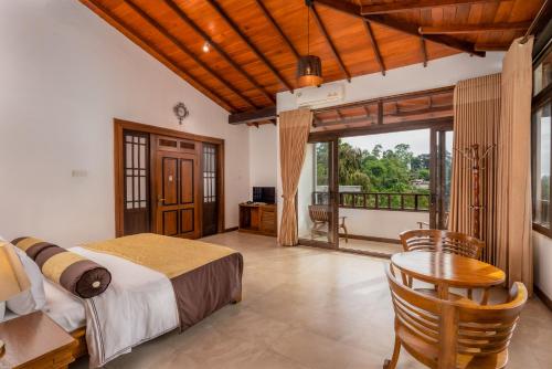 a bedroom with a bed and a table and a balcony at Eagle Regency Hotel in Kandy
