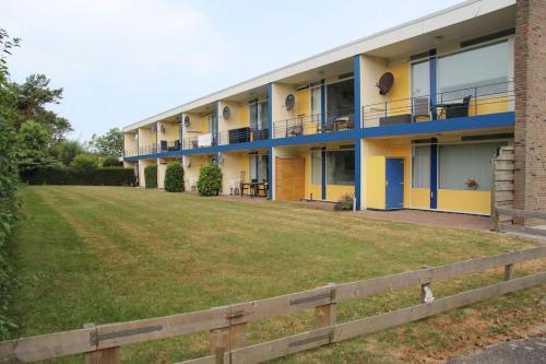 a building with a field in front of it at Appartement Martina 22 in Vlissingen