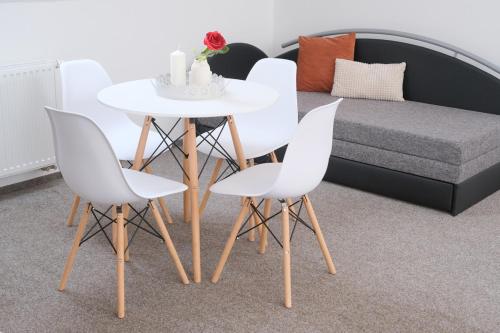 a table and chairs in a living room with a bed at Apartmány Na Kovárně Rájov in Zlatá Koruna