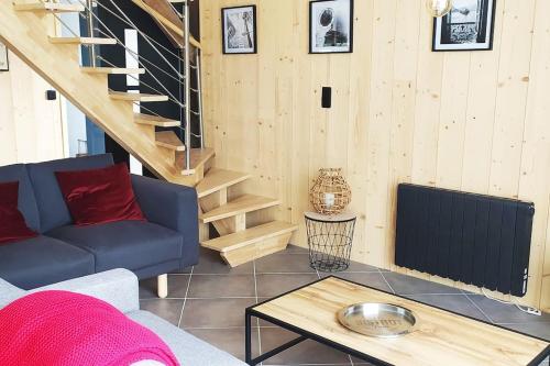 a living room with a blue couch and a staircase at Le gîte de la Ferme in Portbail