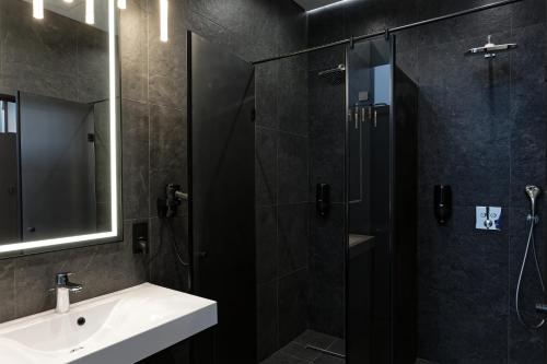a bathroom with a shower and a sink and a mirror at Glacier Premium Apartments in Bukovel