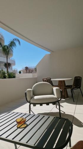 un salon avec une chaise et une table dans l'établissement Archipel Coté Jardin, à Valras-Plage