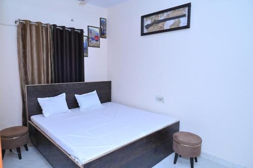 a bedroom with a bed with two stools in it at Privyrooms GORAKHPUR in Gorakhpur
