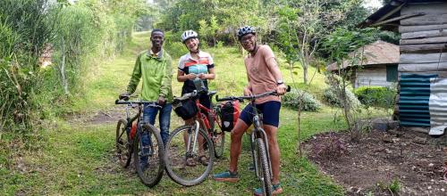 two men and a woman standing with their bikes at Lake Lyantonde Eco-Campsite and lodge in Fort Portal