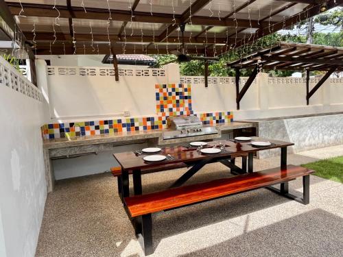 an outdoor kitchen with a table and a bench at Jitsin Villa Koh Tao in Koh Tao