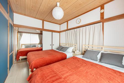 two beds in a room with wooden ceilings at 新大塚戸建て in Tokyo