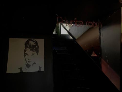 a staircase with a picture of a woman on the wall at Penthouse Flamingo in Palanga