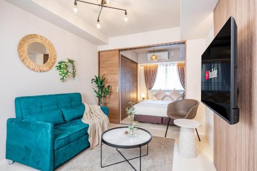 a living room with a green couch and a bed at FDS Serene in Osaka