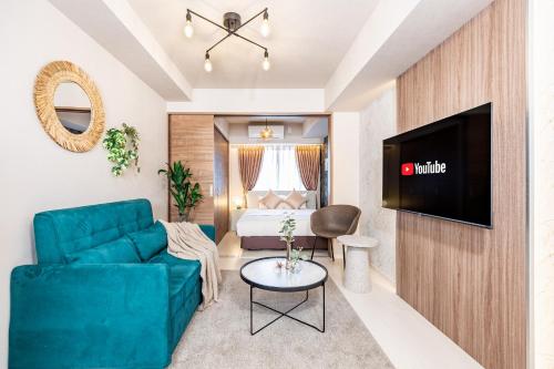 a living room with a couch and a tv and a bed at FDS Serene in Osaka