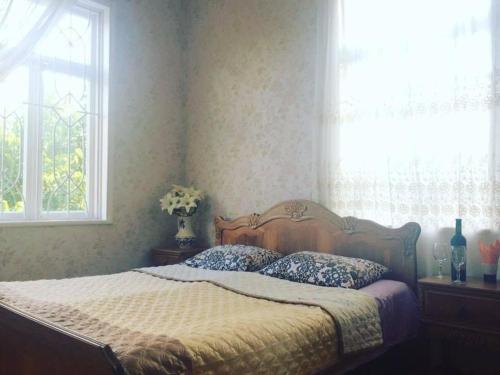 a bedroom with a bed with two pillows and a window at guliko's home in Bostana