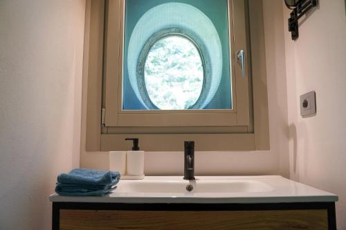 a bathroom with a sink with a window above it at Appartamento laForte - casaDELRESTO in Gaiola