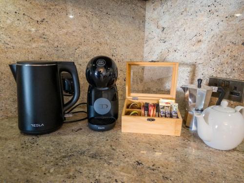a coffee maker sitting on a counter next to a box at KIMRAY Boutique Apartment - Indulge in Comfort, Embrace Tranquility in Marsaskala