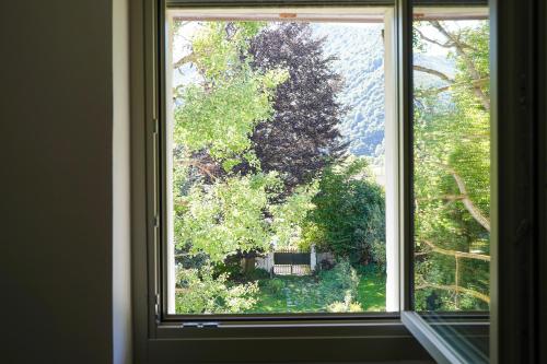 an open window with a view of a garden at Appartamento laForte - casaDELRESTO in Gaiola