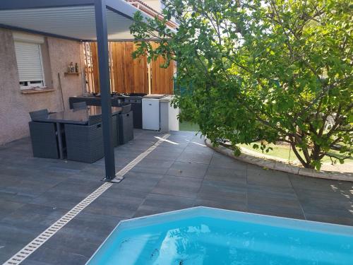 une piscine dans une cour arrière avec une cuisine et un arbre dans l'établissement Maison proche pointe rouge, à Marseille