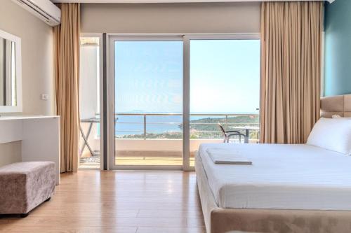 a bedroom with a bed and a view of the ocean at Aphrodite's Garden in Himare