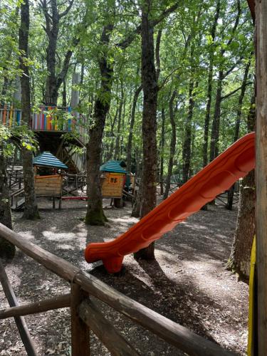 a red slide in a park with a playground at Daunia Avventura in Biccari