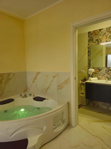 a bathroom with a tub with green water in it at B&B Giardino Isabella in Palagiano
